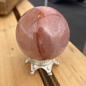 Beautiful polished fire quartz sphere on stand